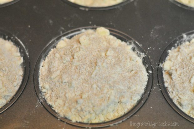 Streusel topping is added to the top of the lemon coffee cake muffins before baking.