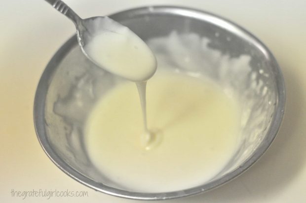 A lemon glaze is mixed to drizzle on the finished muffins.