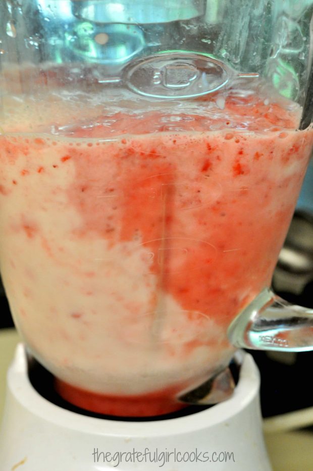 Strawberries and a bit of almond milk are pureed in a blender.
