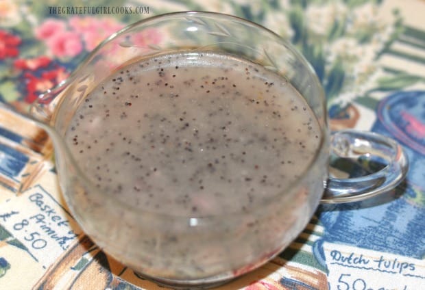 Poppyseed dressing is drizzled on the finished salad.