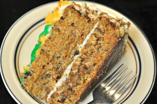 A big slice of Edie's carrot cake, on plate with a fork.