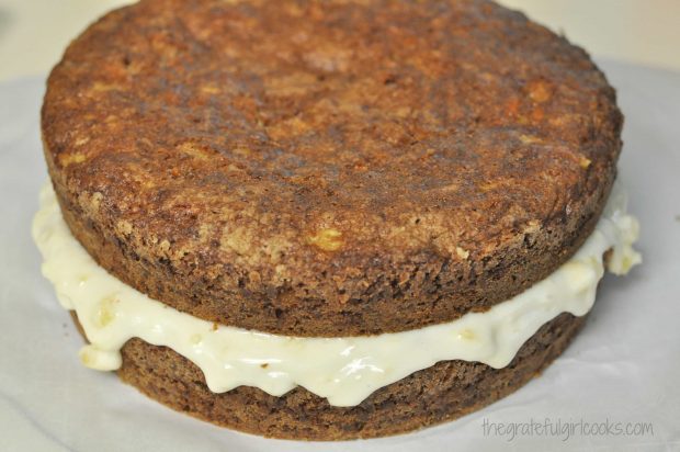 Two layers of Edie's carrot cake, with frosting in the middle.