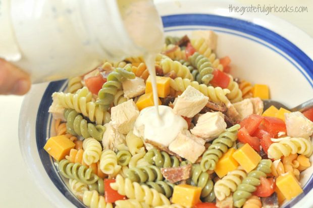 Creamy dressing is poured over pasta salad