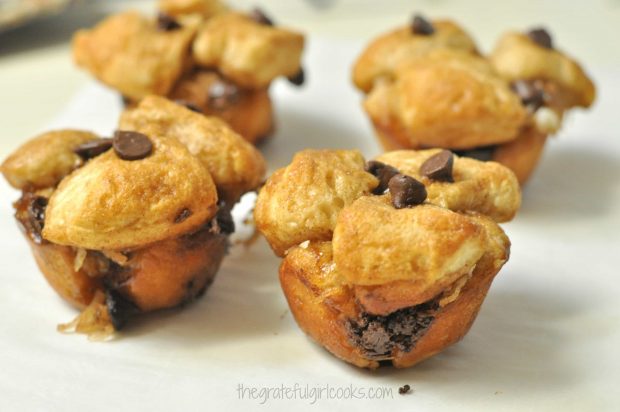 Chocolate chip coconut monkey bread minis are baked, then cool down on parchment paper.