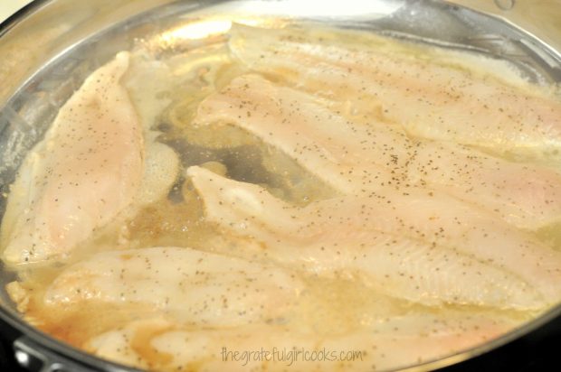 Seasoned Dover sole fillets added to brown butter in skillet.