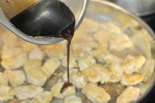 Sauce is poured over the chicken pieces in skillet.