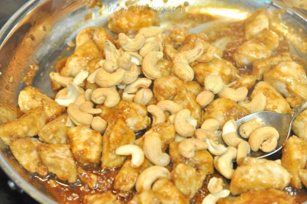 Cashews are added to chicken and sauce.