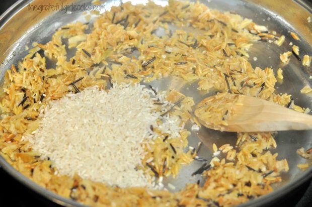 White rice and seasonings are added to the homemade rice pilaf in skillet.