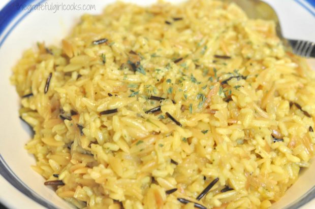 Rice pilaf is garnished with dried parsley, in a bowl.