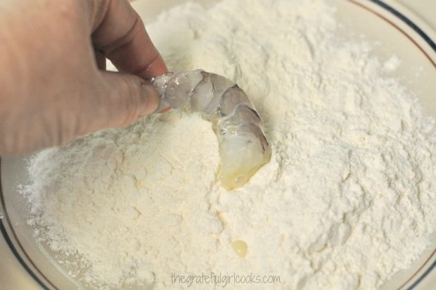 Shrimp are coated in flour mixture before frying.