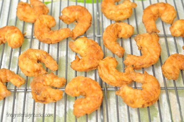 Fried shrimp drain on wire rack before serving.