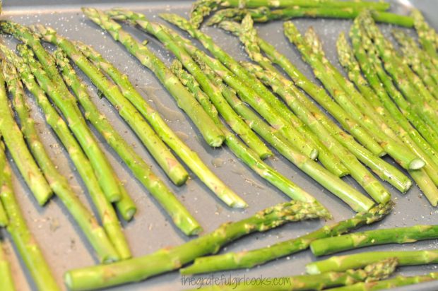 Asparagus is seasoned with salt, pepper and garlic olive oil before roasting