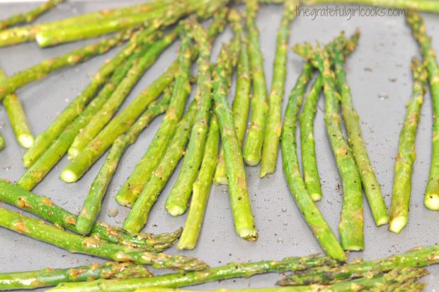 Asparagus on baking sheet halfway through roasting time