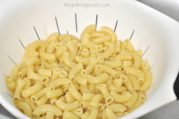 Macaroni noodles are cooked, then drained.