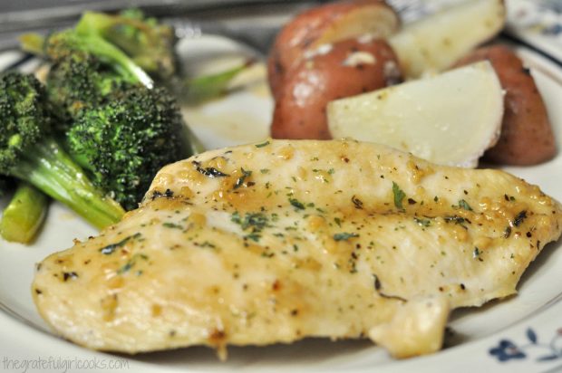 Baked honey garlic chicken is served with sauce, potatoes and broccoli.