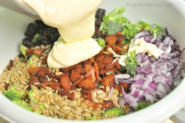 Broccoli Salad is topped with a creamy homemade dressing, then mixed together.