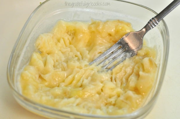 Mashed bananas in dish, ready to add to batter for oatmeal chocolate chip cookies.