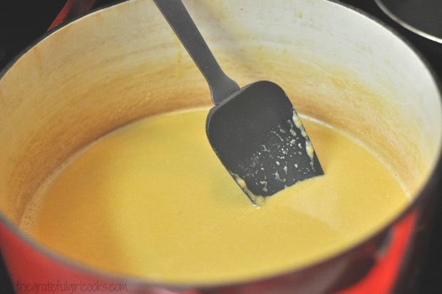 Ice cream ingredients in red saucepan with spatula