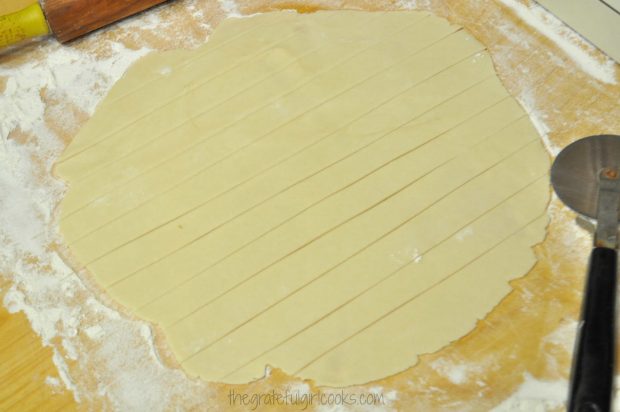 Pie dough is cut into strips for lattice top for deep dish pie.