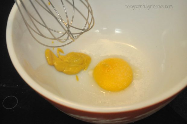 Egg yolk, mustard, salt and sugar are mixed together to start making homemade mayonnaise