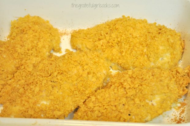 Chicken breasts with tortilla chip topping in white baking pan