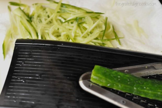 Cucumber is julienne sliced on a mandoline.