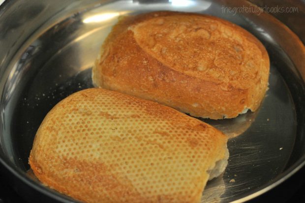 Toasting french roll in skillet before making sandwich.