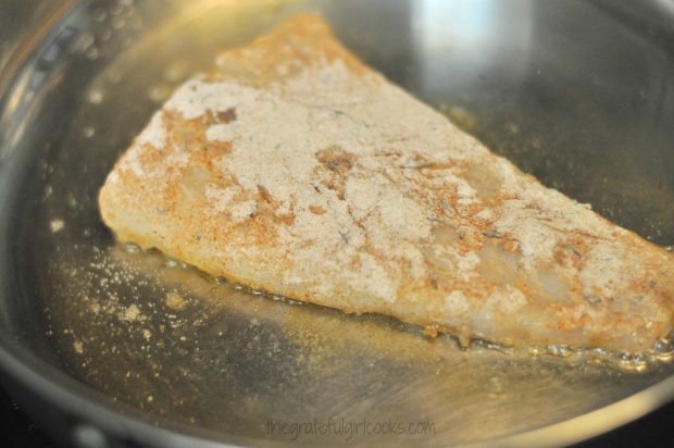 Dredged fish is pan-seared in skillet for sandwich.