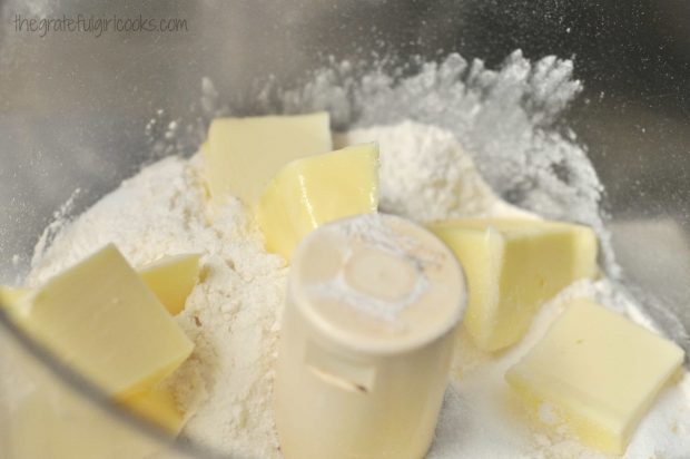 Crust ingredients, including butter, are mixed in a food processor.