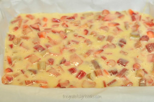 The strawberry and rhubarb filling is spread over the crust before baking.