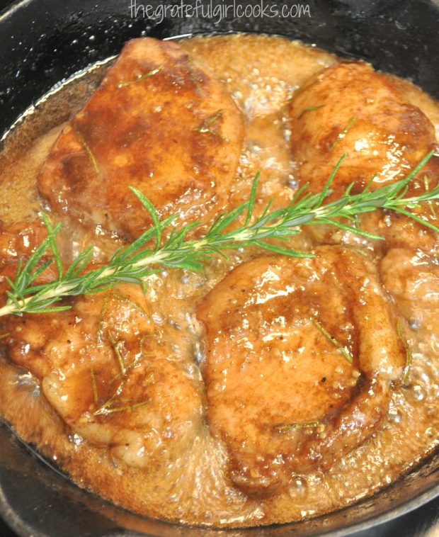 Cooked pork with rosemary sprig in skillet