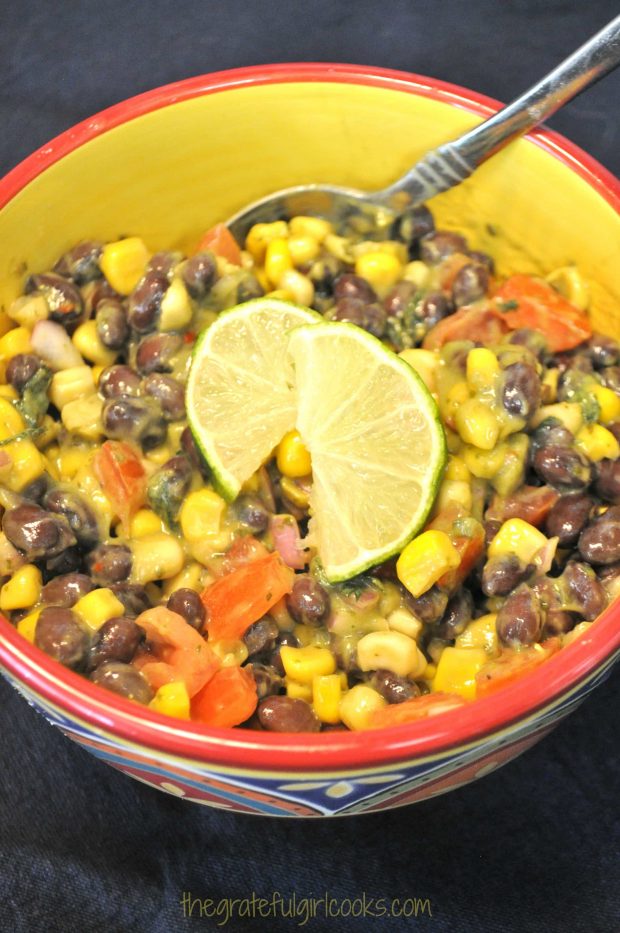The black bean corn tomato salad is served in a colorful bowl, with a lime wedge on top.