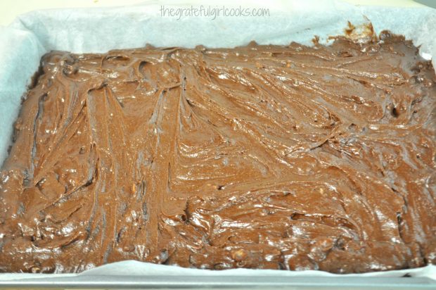 The batter for JB's best brownies is added to a parchment paper lined baking pan.