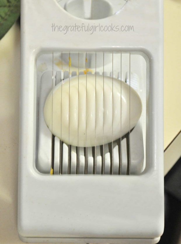 Hard boiled egg in slicer for potato salad garnish.