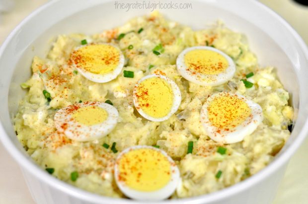 Potato Salad in white bowl, with sliced egg garnish.