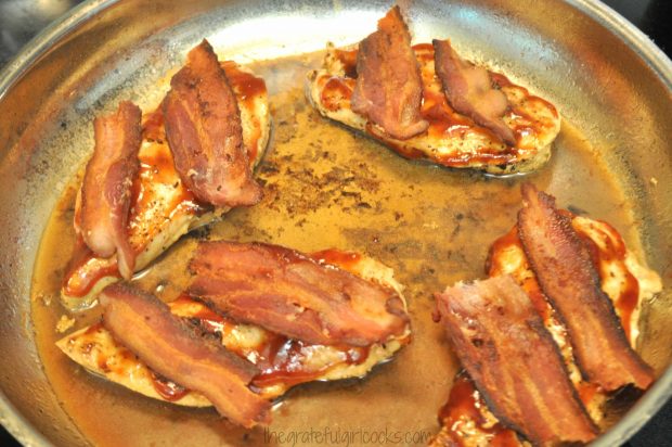 Two cooked bacon halves are added to the Skillet Monterey Chicken.