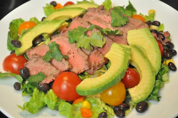 Avocado and steak slices are added to the top of the Southwest steak salad.