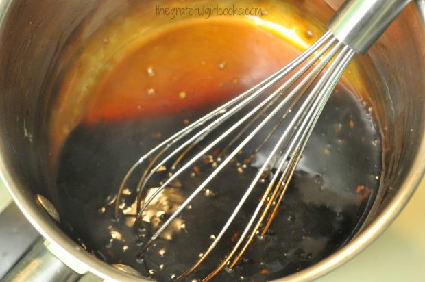 Whisking and cooking homemade teriyaki sauce in saucepan