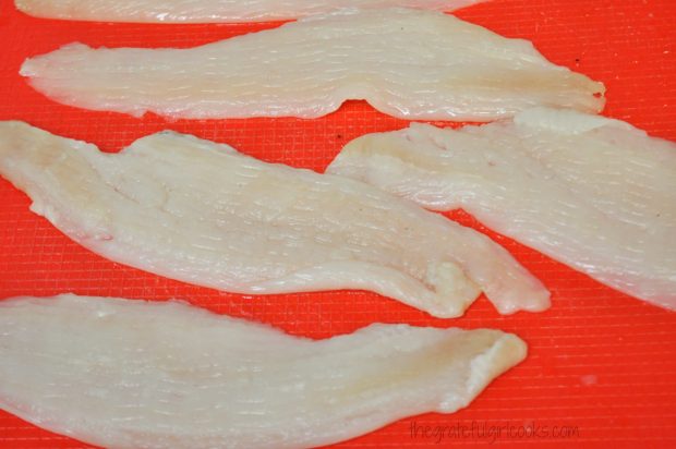 Raw dover sole fish fillets on red work surface