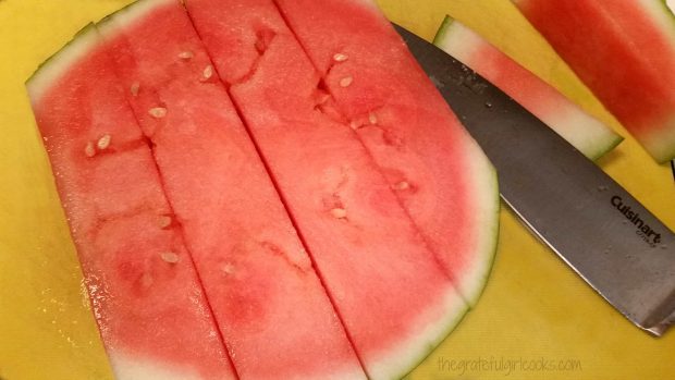 Slicing the watermelon before cubing.