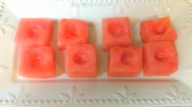 Watermelon cubes have a small round scooped out of them before filling.