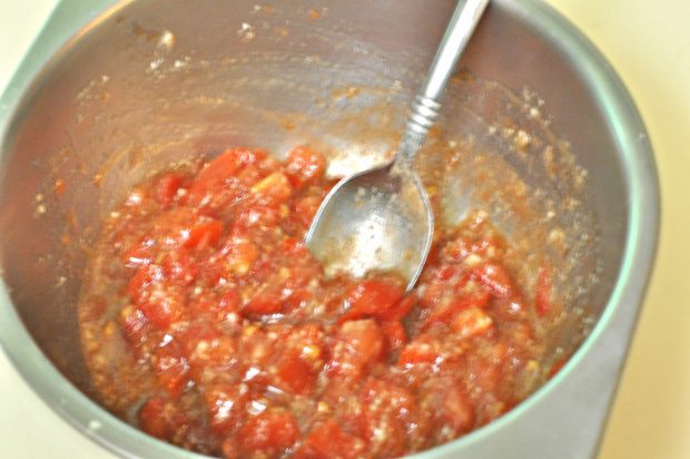 Tomatoes and spices are mixed to make topping. 