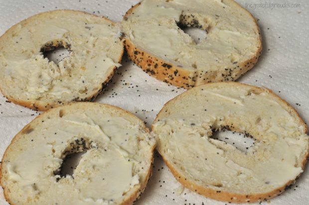 Bagels are sliced in half and buttered for broiling.