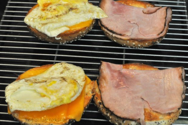 Fried egg and ham slices are added to breakfast sandwich.