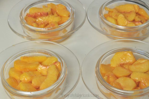 Peach slices placed into individual baking dishes.