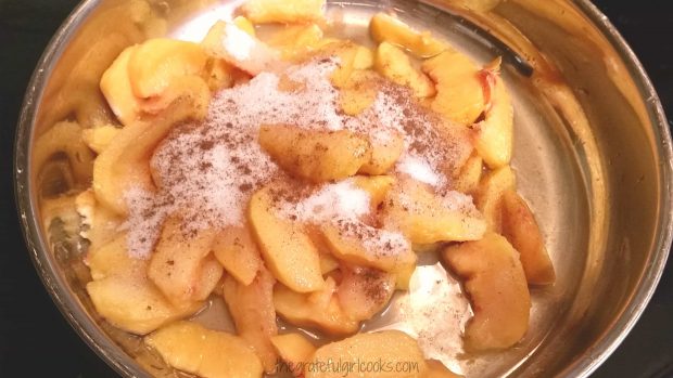 Peaches, cinnamon, sugar and water cooking in a skillet.