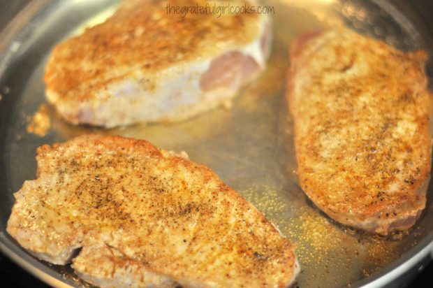 Seasoned pork chops are pan-seared until brown.