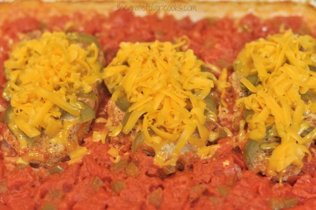 Baked pork chops olé are covered with cheese, placed back in oven to melt cheese.