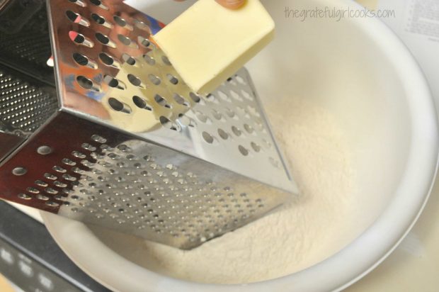 Grating frozen butter for biscuit dough into bowl