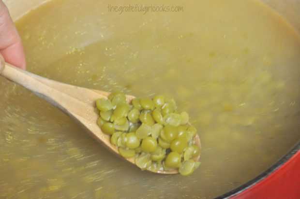 Dried split peas are cooked until tender for split pea and ham soup.